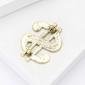 Detailed back view of golden dollar sign brooch showing secure pin fastener mechanism