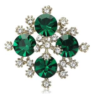 Elegant silver brooch featuring green emerald stones and white zircon diamonds