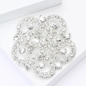 Gros plan d'une broche fleur en strass étincelants avec motif ajouré en métal argenté