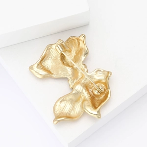 Detail view of the gold-tone petal brooch back showing the pin and secure clasp