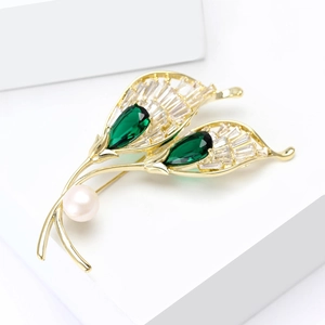 Elegant gold leaf brooch with green gemstones, square zircons, and a pinkish pearl