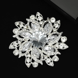 Détail de la broche fleur de soleil argentée avec des pétales en strass étincelants