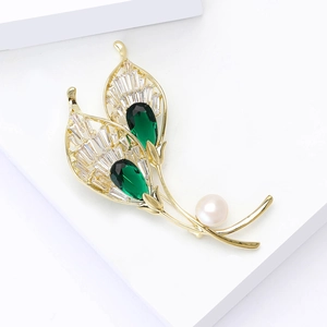 Elegant gold leaf brooch with green pear-cut stones, clear zircons, and a white pearl