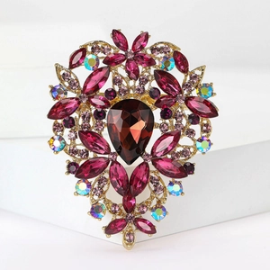 Macro view of vintage alloy brooch with large red teardrop stone and purple rhinestones