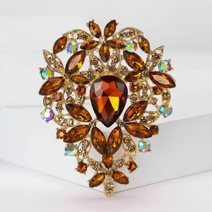Macro detail of luxury vintage gold brooch with amber crystal and teardrop gemstone