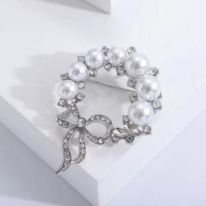 Elegante spilla a ghirlanda con fiocco argento con perle bianche e strass scintillanti