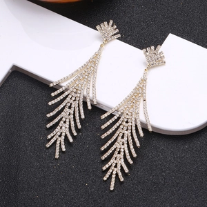 Detail of leaf-shaped dangling earrings with gold plating and sparkling crystal tassels