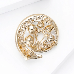 Broche de perlas y strass dorado con patrón hueco y vista posterior de alfiler sobre blanco