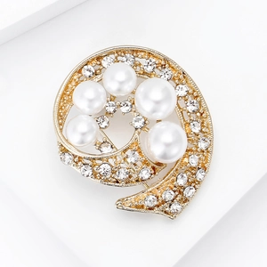 Detalle macro de un elegante broche de remolino dorado con pedrería y perlas finas