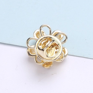 Vue détaillée du dos de la broche fleur dorée avec fermeture à clip rotative
