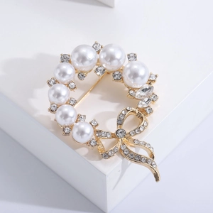 Elegante spilla a fiocco in lega dorata con perle bianche e strass di cristallo scintillanti