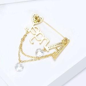 Détail de la broche lettre Angel dorée avec pierres en zircon et pampilles suspendues