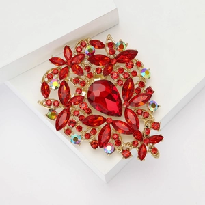 Vintage gold alloy brooch with large red teardrop gemstone and sparkling rhinestones