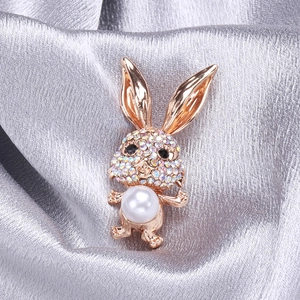 Broche lapin mignonne en or rose avec strass colorés et perle blanche sur fond de soie