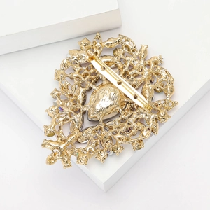 Close-up of the vintage gold alloy brooch back featuring hollow texture and safety pin