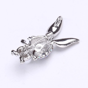 Vue détaillée du dos d'une broche lapin argentée avec épingle de sûreté et strass brillants