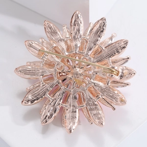 Détail arrière d'une broche tournesol montrant la finition or rose et l'épingle de sûreté