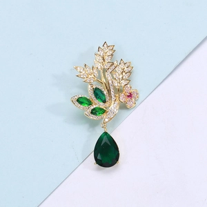 Broche fleur dorée élégante avec zircons et pendentif en cristal vert en forme de poire