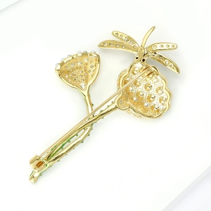 Detail view of the golden dragonfly brooch back showing the secure safety pin closure