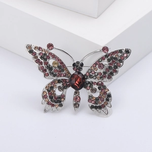 Eleganter Schmetterling-Anstecknadel mit bunten Kristallen auf einem weißen Podium