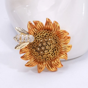 Macro shot of sunflower bee brooch with gold metallic petals and sparkling zircon inlay