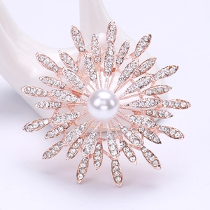 Detailed macro view of luxury sunflower brooch with rose gold petals and central pearl inlay