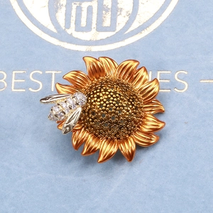 Close-up of sunflower bee brooch with gold petals and sparkling zircon honeycomb details