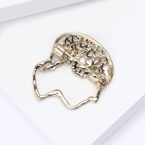 Detailed back view of gold-tone female profile brooch showing pin clasp and hollow pattern