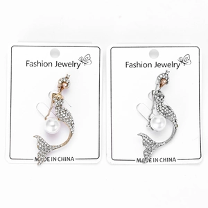 Detail view of gold and silver mermaid brooches with rhinestones and white pearls