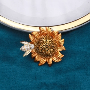 Sunflower and bee brooch with zircon pavé on a dark velvet background for fashion cardigan