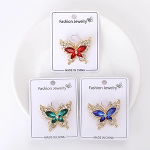 Detailed view of rhinestone butterfly brooches in red, green and blue crystal colors