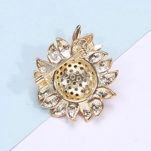 Detail view of the back of a gold sunflower brooch showing the pin clasp and openwork
