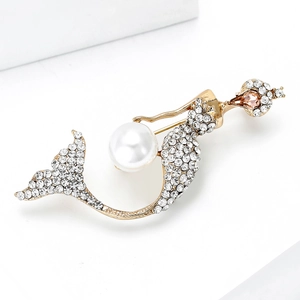 Close-up of golden mermaid brooch with sparkling rhinestones and a white pearl accent