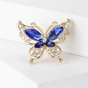 Macro shot of butterfly brooch with blue marquise stones and white rhinestones in gold