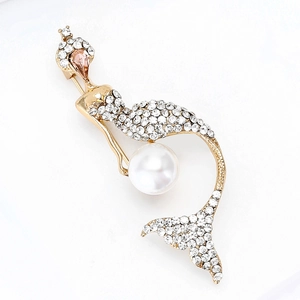 Close-up of golden mermaid brooch featuring white rhinestones and a large round pearl