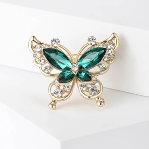 Detail of butterfly brooch with emerald green gems and clear rhinestones on gold alloy