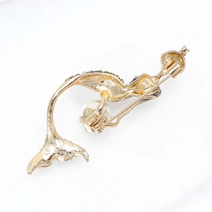 Elegant gold mermaid brooch with white pearl and sparkling crystals on white background