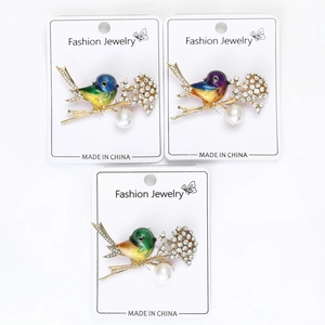 Detail of bird brooches with enamel gradient colors, white rhinestones and a faux pearl