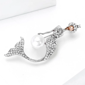 Detailed view of mermaid brooch with rhinestones and white faux pearl on silver base