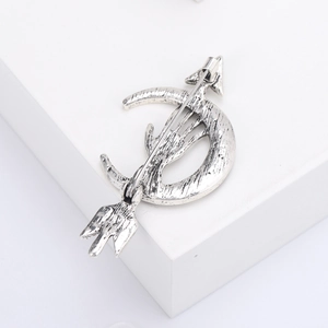 Detailed view of vintage silver arrow and moon brooch with textured antique finish