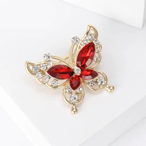 Detail of butterfly brooch with red marquise crystals and golden alloy hollow design