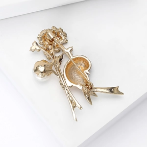 Elegant gold flower brooch with pearl detail and pin fastener in vintage style