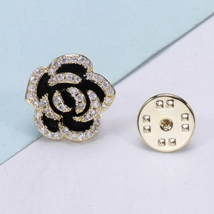 Close-up of camellia brooch with gold plating, sparkling zircons, and black enamel inlay