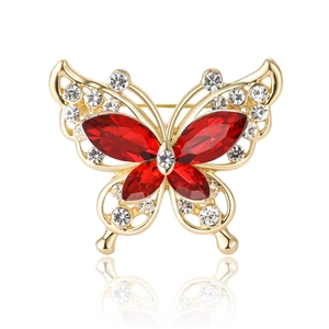 Close-up of golden butterfly brooch with red gems and sparkling crystal rhinestones