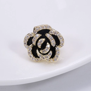 Macro detail of camellia brooch with black petals and gold plated zircon edges