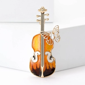 Détail macro d'une broche violon avec émail dégradé et incrustation papillon cristal