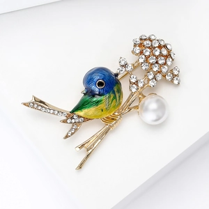 Detail view of colorful enamel bird brooch with sparkling rhinestones and a large pearl