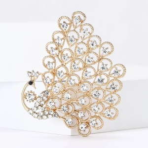 Detailed close-up of a peacock brooch with golden alloy and shimmering rhinestones