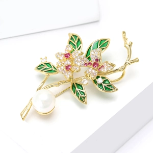 Luxurious gold flower brooch with micro-pave crystals, green enamel leaves and large white pearl