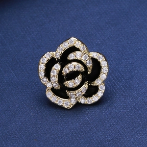 Close-up of camellia brooch with black enamel petals and micro-set cubic zirconia crystals
